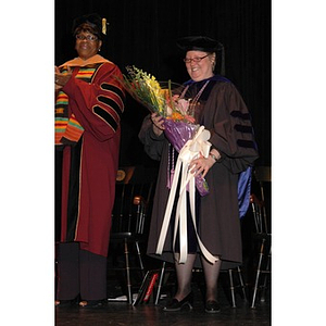 Faculty member poses with flowers at School of Nursing convocation