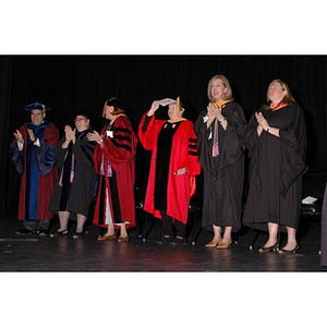 Faculty members stand onstage at School of Nursing convocation