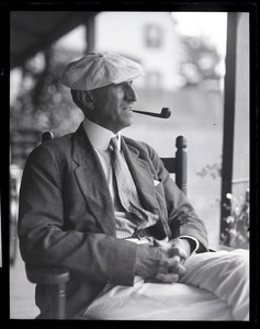 Uncle Joe Holland, seated on a porch, smoking a pipe
