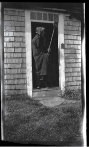Reuben Austin Snow, the cross-dressing hermit of Cape Cod, in doorway to house