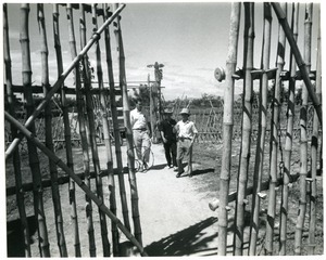 David Entin with two men through bamboo gate
