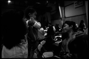 Cambodian New Year's celebration: man with baby holding cash, and drummer