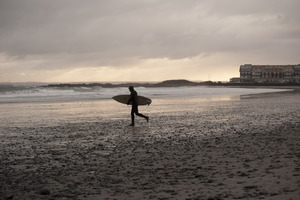 Surfer heading with his board to the water