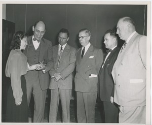 Five men examining a woman's artificial arm