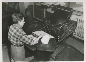 Young man presses envelopes at a sheltered workshop