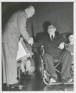 Dwight D. Eisenhower shakes the hand of a man in wheelchair