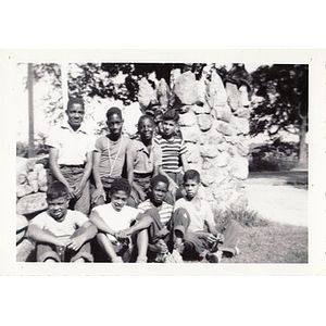 A group of campers pose against a stone wall at Breezy Meadows Camp
