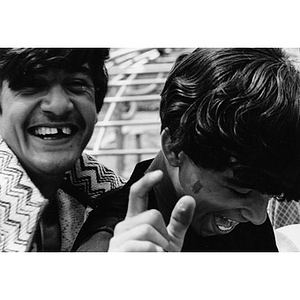 Two Latino youths laughing at an athletic field or playground in Roxbury, Mass., while attending a recreational event sponsored by La Alianza Hispana.