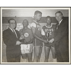 Sheriff Frederick Sullivan, at far left, and Jack Crowley present three young men with the Boys' Club basketball tournament awards at the Charlestown gym