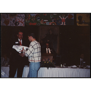 A man presents an award to a young man at a Boys and Girls Club awards event