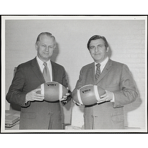 Frederick J. Davis, on the right, and an unidentified man, holding footballs at a Boys' Club's event with New England Patriots