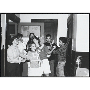 Site coordinator Liz Cinquino and group of children gather in a room for the Tri-Club slide show at the Charlestown Clubhouse