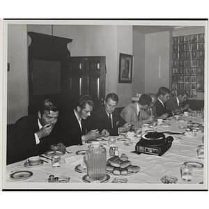 Committee members eat and converse at a Boys' Club event