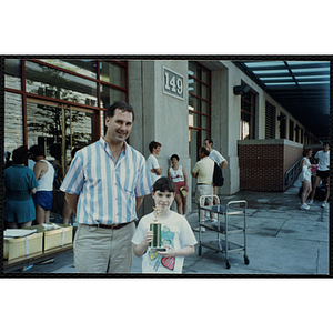 A man poses with a girl holding a trophy during the Battle of Bunker Hill Road Race