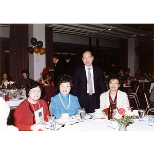 Chinese Progressive Association director Suzanne Lee (seated, first from right) in a group photograph with two other women and one man at the Rainbow Leadership Award Ceremony and Dinner at Boston University