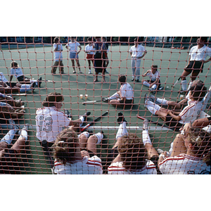 Women's field hockey team sitting on the field