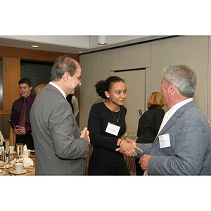 President Aoun watches Melanie Arvajo shake hands with a man at the Torch Scholars dinner