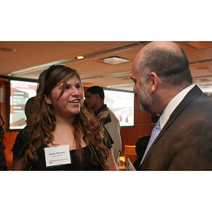 Nadia Alvarez converses with a man at a Torch Scholar event