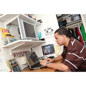 Odalis David Polanco works on his laptop in his dorm room in Stetson West