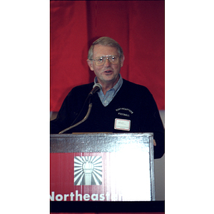 Neal F. Finnegan speaks at a podium at a reception