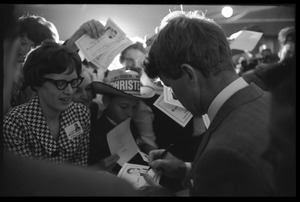 Robert F. Kennedy signing autographs for the crowd after speaking at a dinner while stumping for Democratic candidates in the northern Midwest