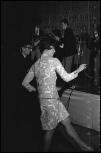 Woman in a paisley print dress dancing energetically to the live band at the JOPA Club