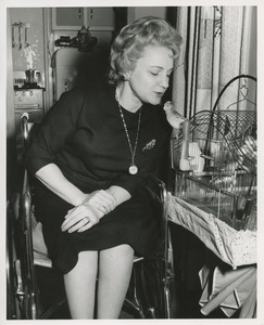 Mrs. Frances Marsala seated in her wheelchair admiring her birdcage