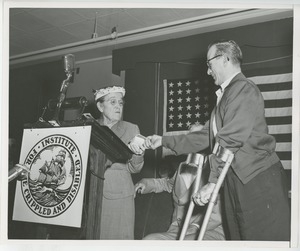 Unidentified woman handing gifts to client at Institute Day