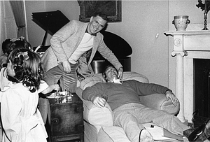 Mayor Raymond L. Flynn seemingly playing a prank on an unidentified resting man at a family function