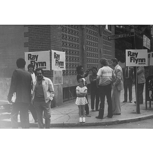 Several people and Carmen Pola stand on the corner of Tremont and Wigglesworth Streets next to "Ray Flynn Mayor" signs