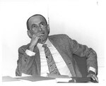 Suffolk University Professor Donald Unger (CAS) sitting at desk, photograph, 1984
