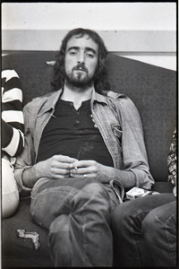 Fleetwood Mac backstage at the Boston Tea Party: John McVie sitting on couch and smoking