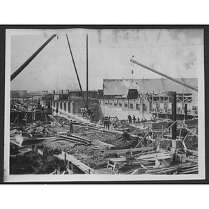 Builders working on a foundation with construction materials and a crane