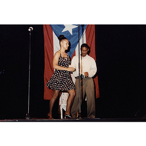 Damaris Padilla dances on stage with a man at the Festival Puertorriqueño