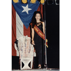 The Jayuya representative, Yaritza Gonzalez, stands in front of a large Puerto Rican flag