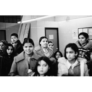 Group of eight girls, one boy, and one woman watch a Three Kings' Day pageant at La Alianza Hispana.