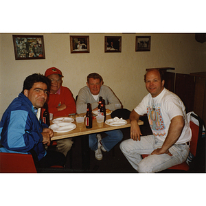 Four men seated around a table with food and drinks at a Boys & Girls Club Golf Tournament