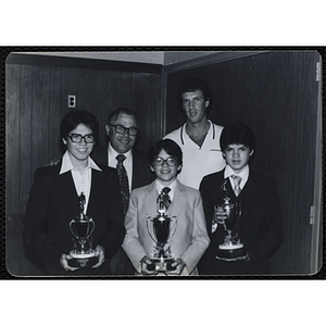 Two men posing with three boys holding their trophies during a Boys' Clubs of Boston Awards Night