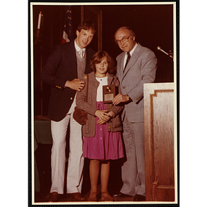 Claudine Houg receives an award from Robert Cleary, Overseer of the Boys' Clubs of Boston, at right, and an unidentified man