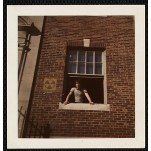 A male staffer standing at the window and looking outside at the South Boston Boys' Club