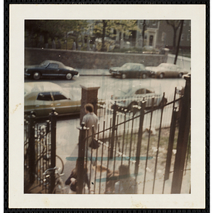 Several girls sitting at the entrance to the South Boston Boys' Club building while a man walks past