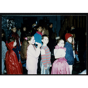 Children in costumes stand in line at a Halloween event