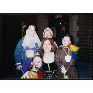 Children in their Halloween costumes pose with a woman