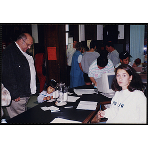 A Young girl signs up for an activity during an open house