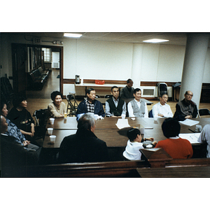 Chinese Progressive Association members sit at a rectangular table