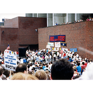 View of NYNEX workers' strike and rally at City Hall Plaza, Boston, with the sign, "It's not Anti-Harvard to be Pro-Union. HUCTW [Harvard Union of Clerical and Technical Workers]" in the left mid-ground