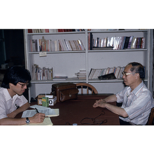 Henry Wong sits at a table for an interview with an unidentified man