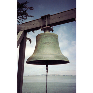 Bell hanging at the waterfront from a wooden frame