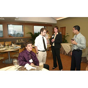 Meghan Allen-Eliason speaks with three students at the Torch Scholars dinner