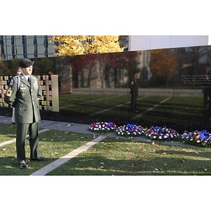A man in military uniform stands next to the Veterans Memorial at the dedication